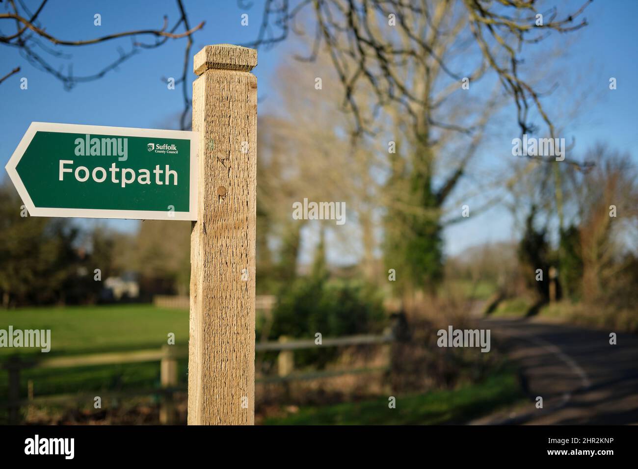 Cartello con il sentiero che punta a destra su un palo di legno su una strada a Suffolk, Regno Unito. Foto Stock