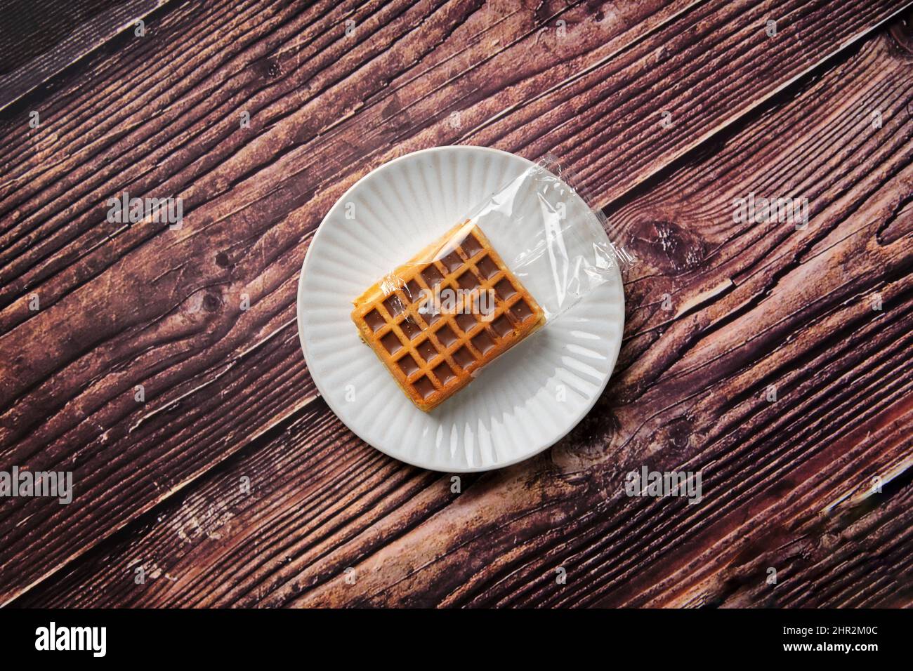Che mostra il problema della plastica monouso, fornita in confezioni da due. Questi waffle dolci con un ripieno di cioccolato sono in plastica monouso. Foto Stock