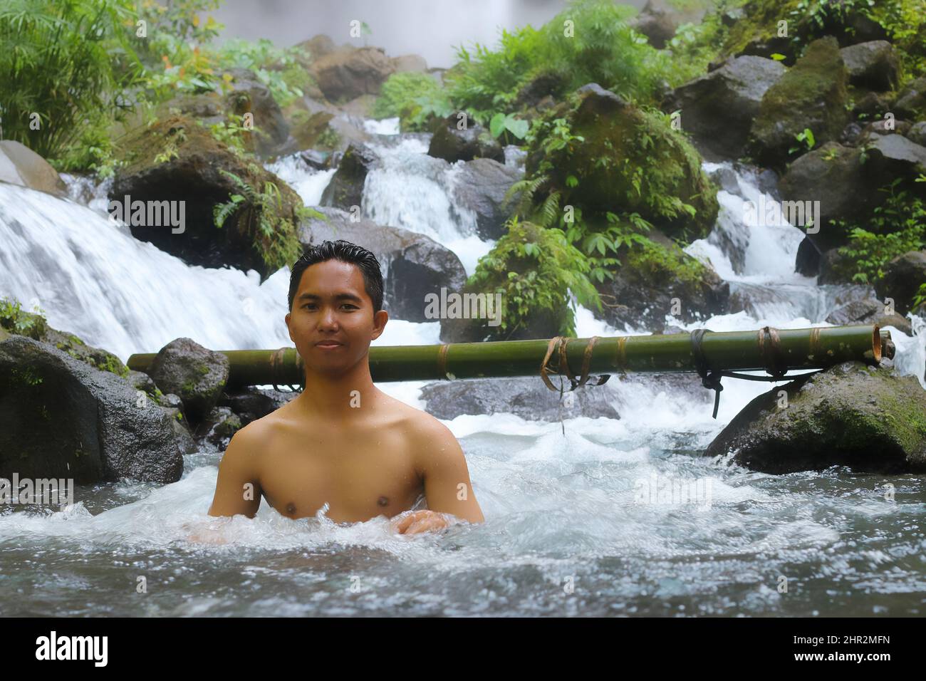 Felice giovane uomo asiatico riposato nel fiume canyon ruscello nella giungla thetropical, paesaggio naturale. Acqua fredda e procedura termale naturale, fauna selvatica e verde Foto Stock