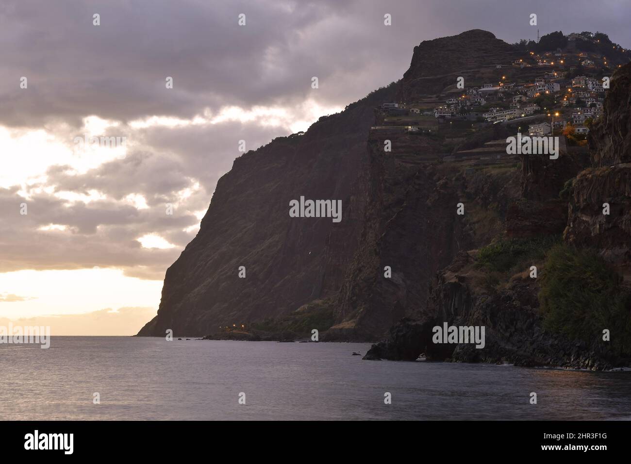 Cabo Girao, alte scogliere vulcaniche viste dalla spiaggia di Praia de Vigário al crepuscolo, situato sulla costa meridionale di Madeira Portogallo. Foto Stock