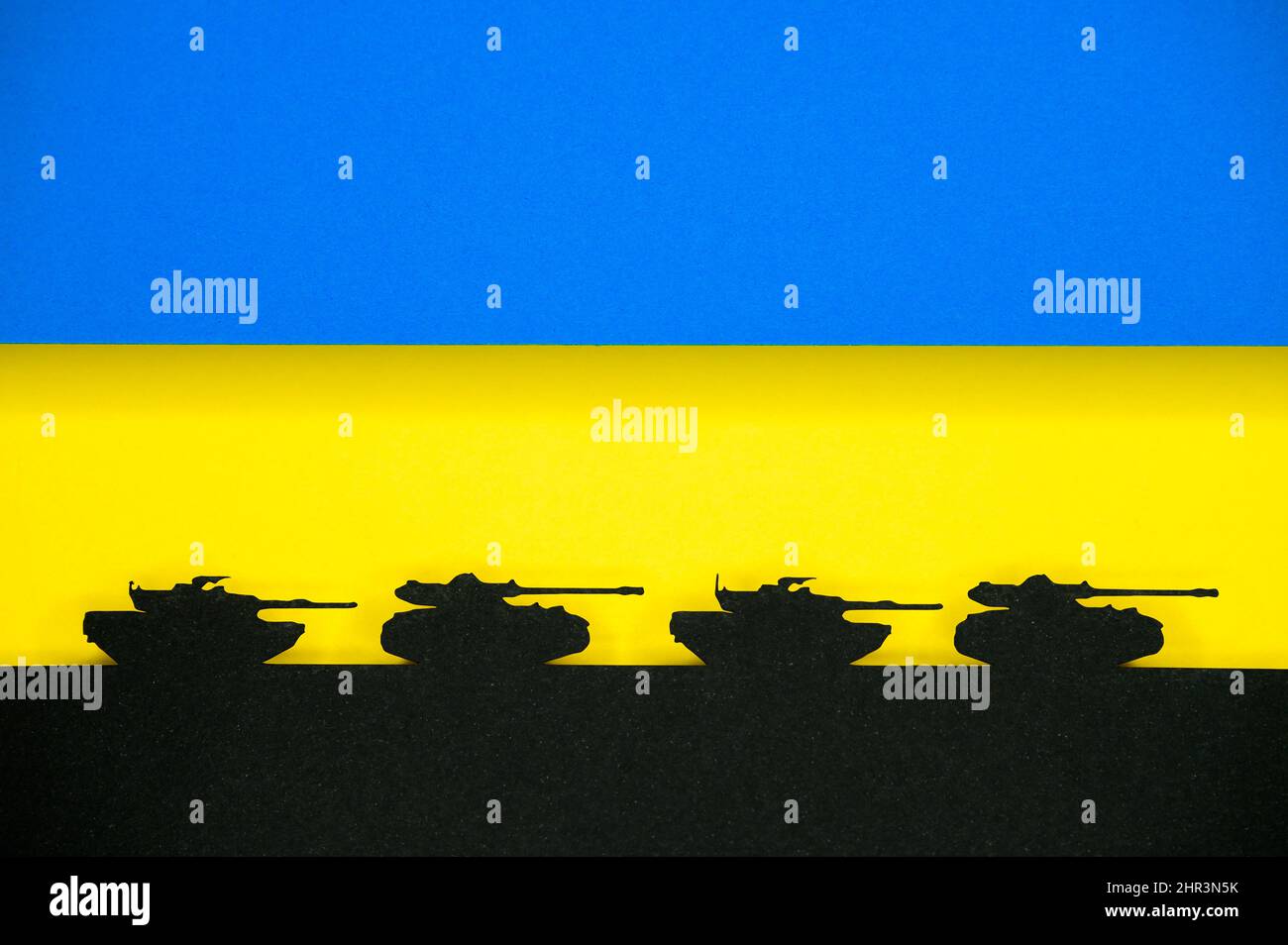 Guerra in Ucraina, foto di illustrazione, Ucraina colori blu e giallo. Silhouette della mappa Ucraina, carri armati neri sullo sfondo. Conflitto tra Russia Foto Stock