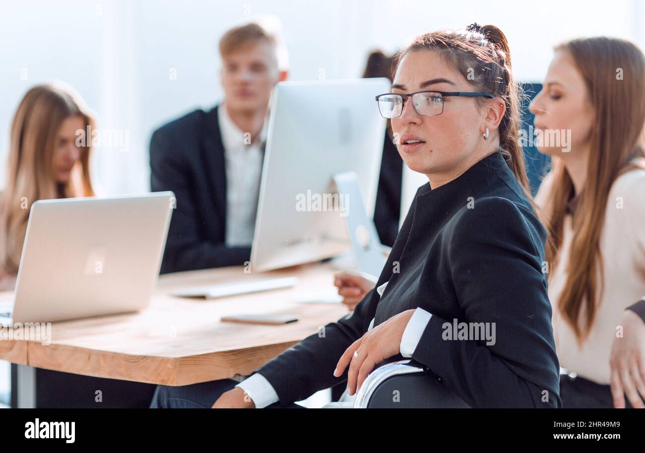 Giovani dipendenti che discutono di qualcosa alla scrivania Foto Stock