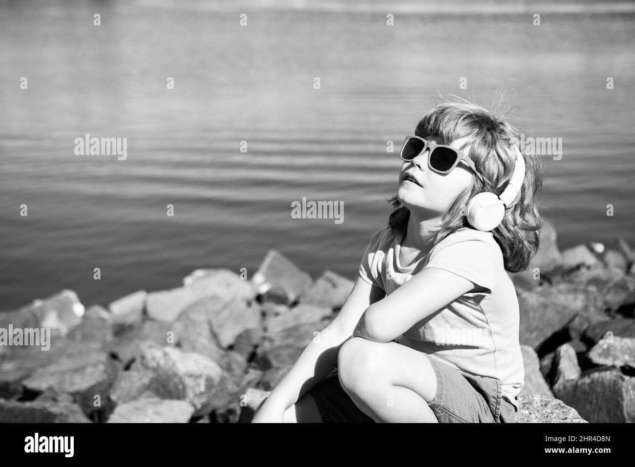 Ragazzo spensierato. Bambino in auricolari all'aperto. Concetto di ascolto della musica. Foto Stock