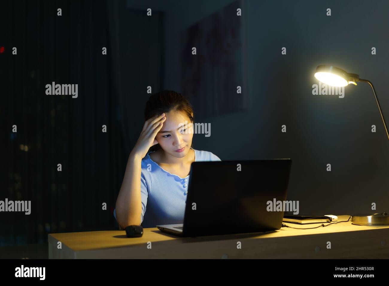 Donna asiatica lavoro a tarda notte stressante con i problemi di ricerca di progetto su un computer portatile o notebook a casa ufficio burnout sindrome concetto. Foto Stock
