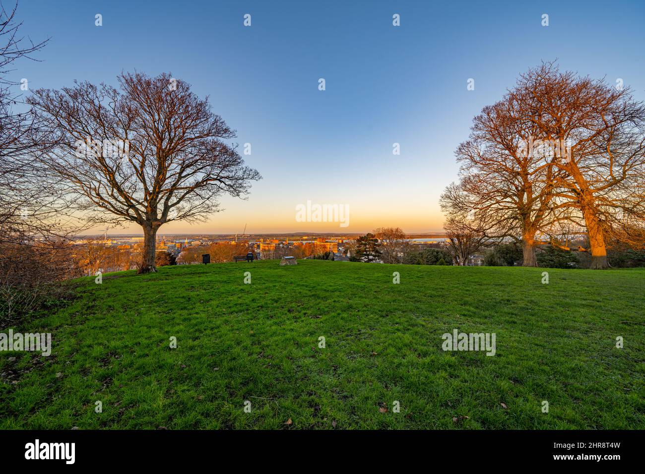 Alberi e la vista verso l'Essex dalla collina di Windmill Gravesend Kent al Tramonto in una serata d'inverno Foto Stock