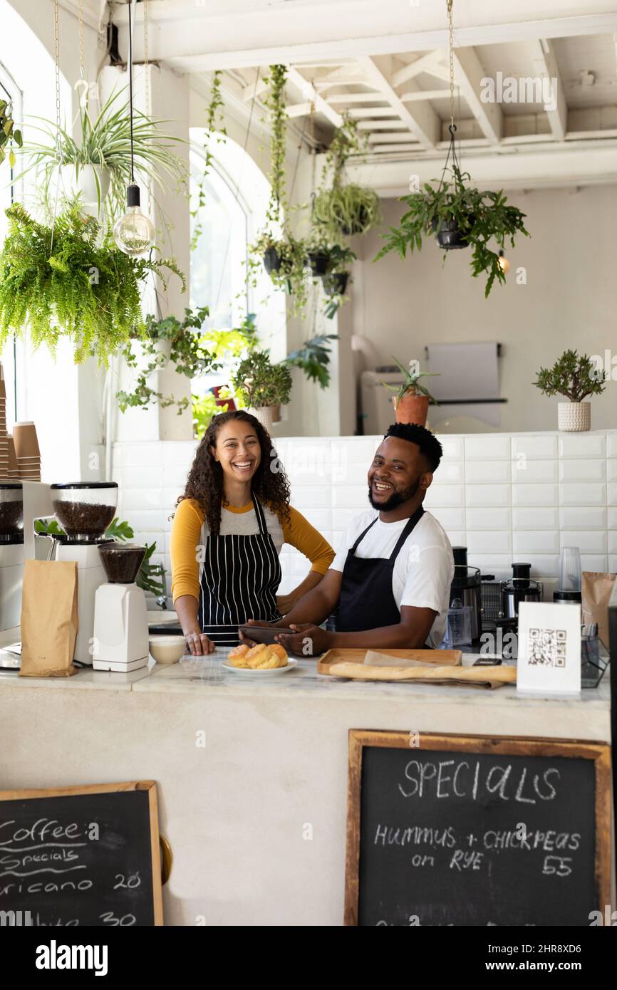 Ritratto di Happy african american barista colleghi in piedi al banco in caffetteria Foto Stock