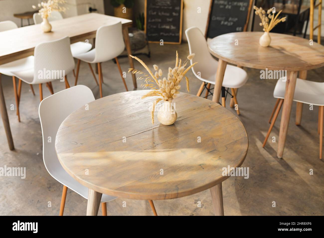 Vista ad angolo alto del vaso decor su un tavolo di legno con sedia nella moderna caffetteria Foto Stock