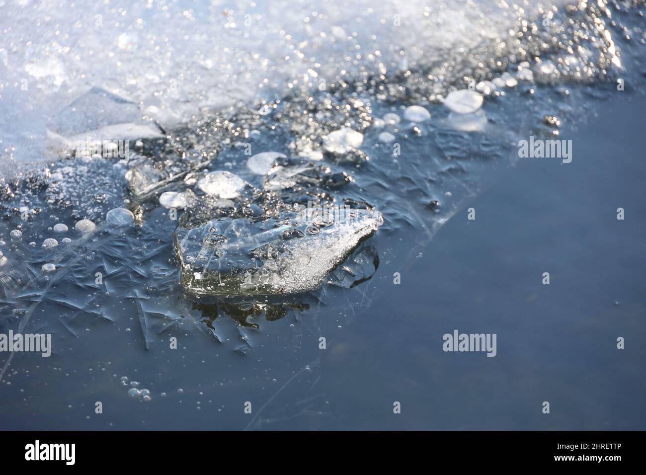 Sciogliendo il ghiaccio sul fiume. Bordo di ghiaccio sulla riva ghiacciata, inizio della stagione primaverile Foto Stock