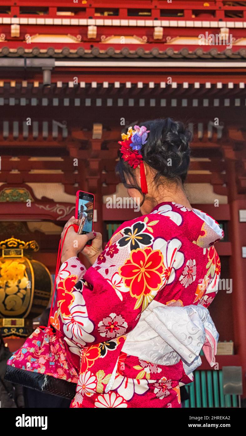 Ragazza vestita in kimono giapponese prendendo selfie di fronte al Tempio Asakusa Kannon (Tempio senso-ji), Tokyo, Giappone Foto Stock