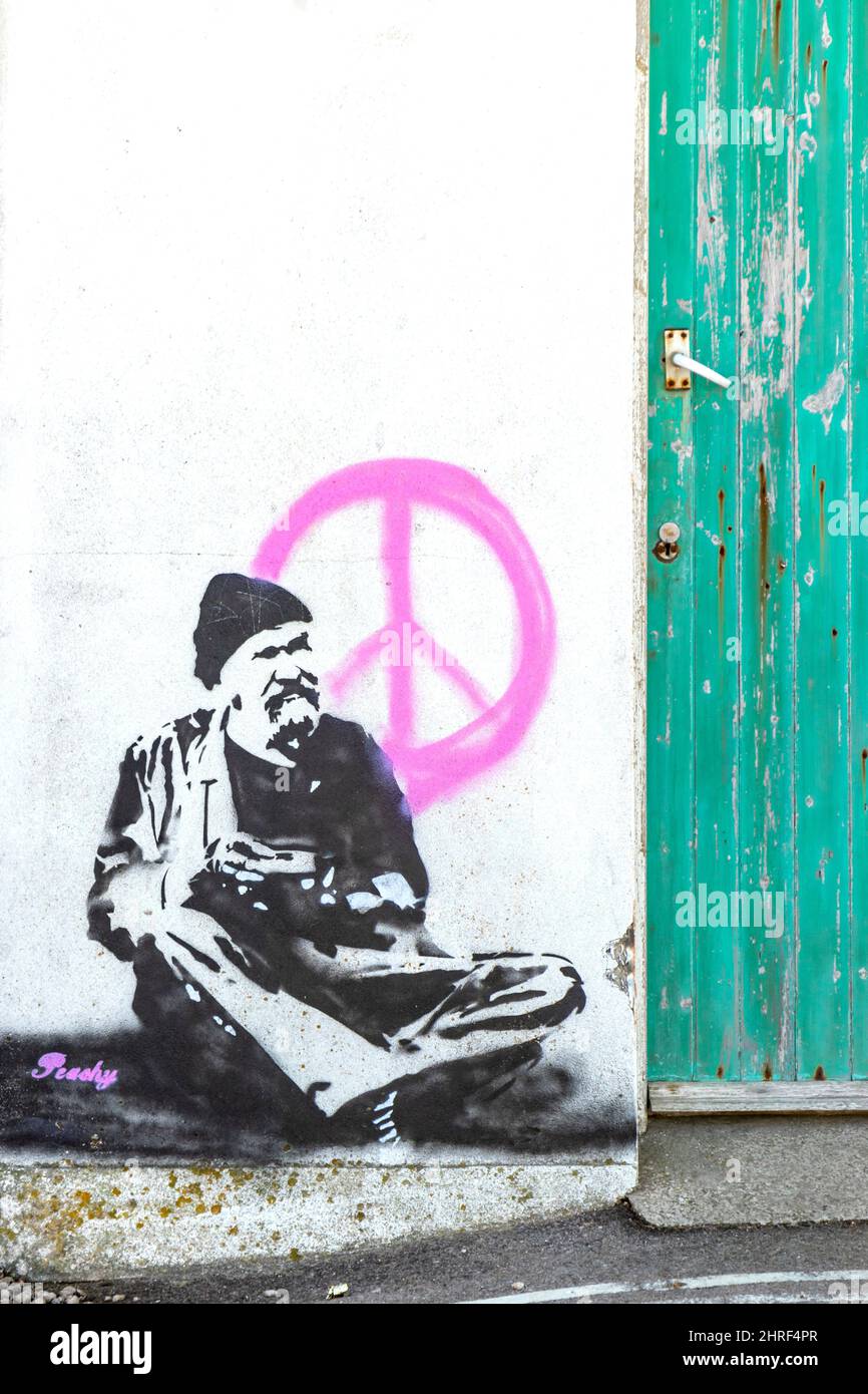 graffiti o stencil dipinto di uomo seduto nello stile di Banksy con il logo CND rosa sull'isola di Portland, Portland Bill Foto Stock