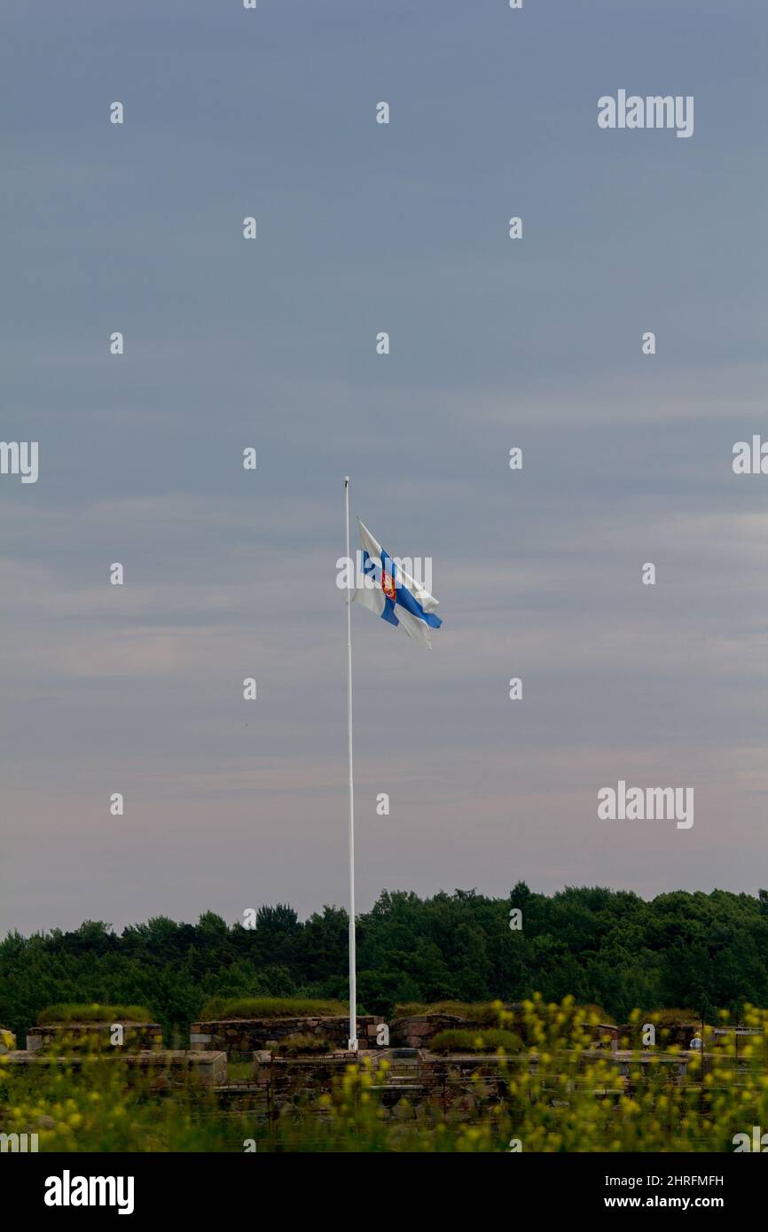 La bandiera finlandese sorvola il forte di Suomenlinna Helsinki, Finlandia. Foto Stock