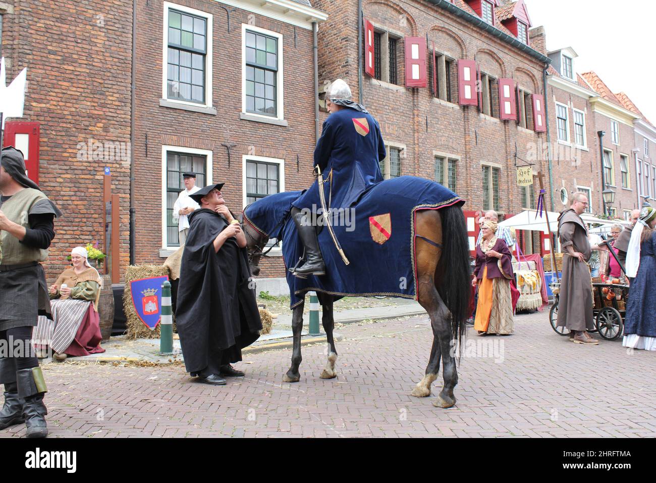 un cavaliere a cavallo cammina per le strade durante i festeggiamenti medievali in estate Foto Stock