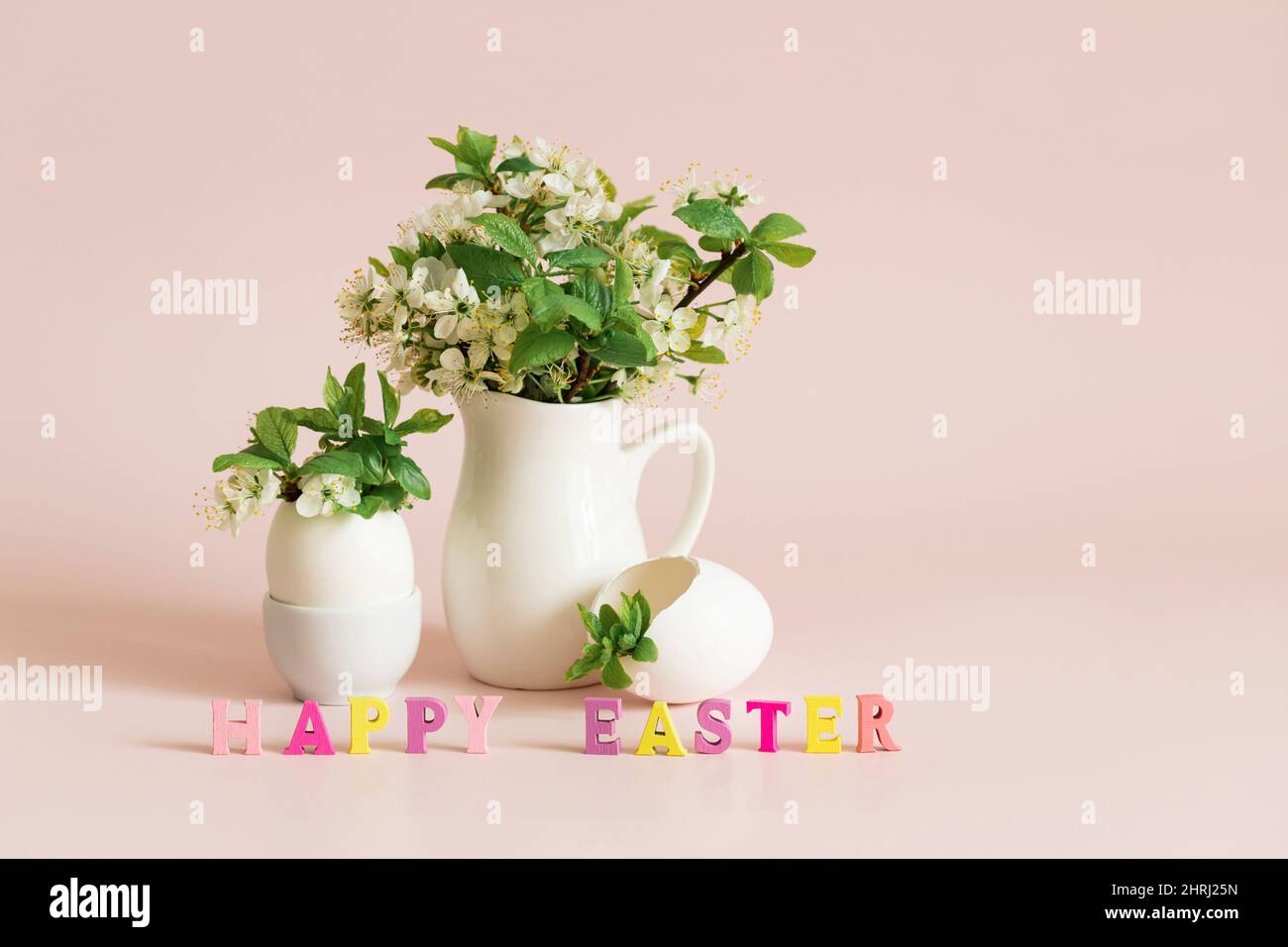Iscrizione buona Pasqua. Biglietto d'auguri di Pasqua con uova e fiori di ciliegia su sfondo rosa. Spazio di copia. Foto Stock