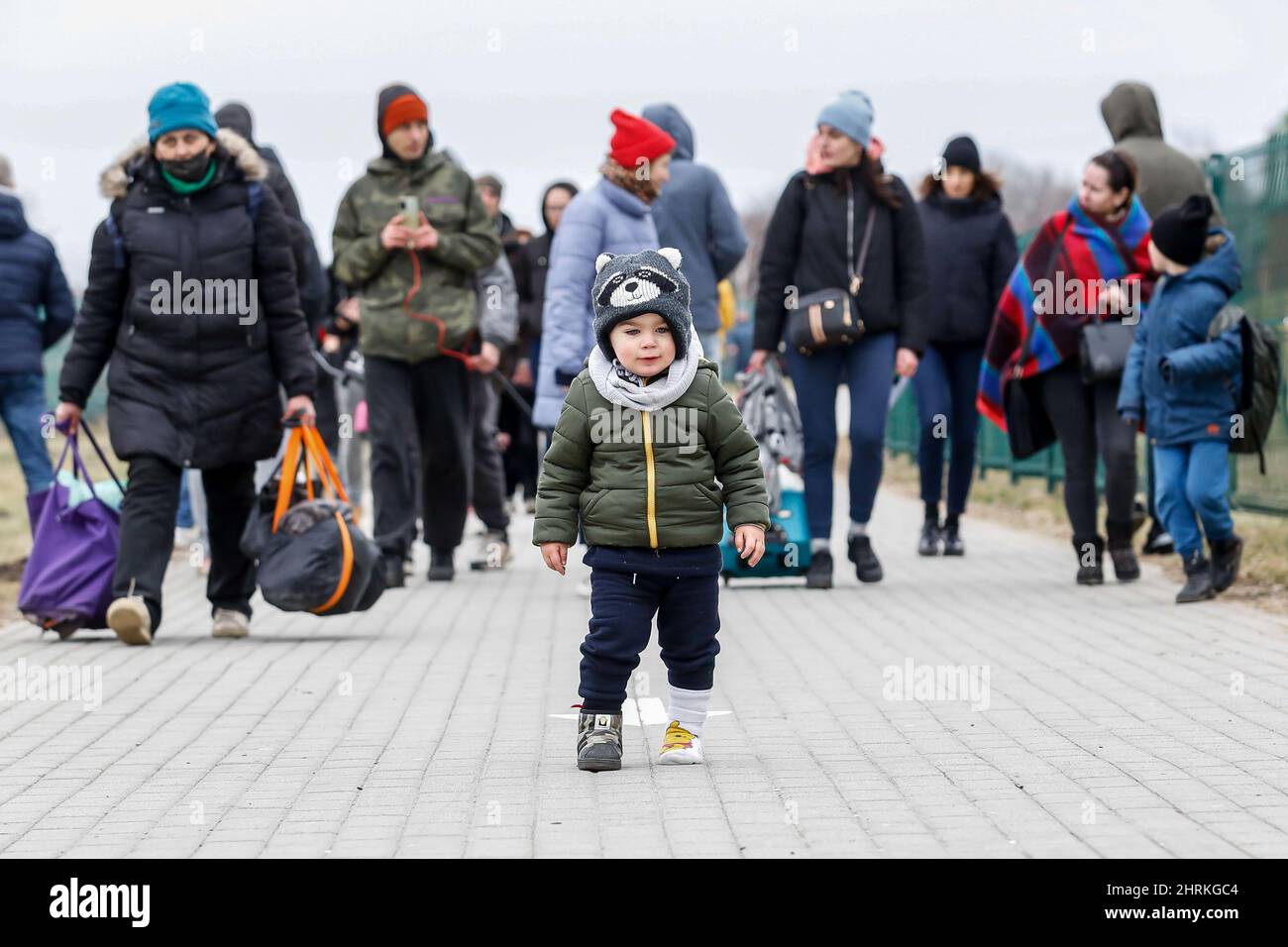 Un bambino e le famiglie ucraine hanno visto camminare attraverso il passaggio di frontiera mentre la Russia prende più territorio ucraino. Mentre l'esercito della Federazione russa ha attraversato i confini ucraini, il conflitto tra Ucraina e Russia dovrebbe costringere alla fuga 5 milioni di ucraini. La maggior parte dei rifugiati chiederà asilo in Polonia. La maggior parte degli attuali fuggiti sono famiglie di quegli ucraini che già lavorano in Polonia. I valichi di frontiera sono pieni di migliaia di uomini e donne in attesa dei loro cari. (Foto di Dominika Zarzycka/SOPA Images/Sipa USA) Foto Stock