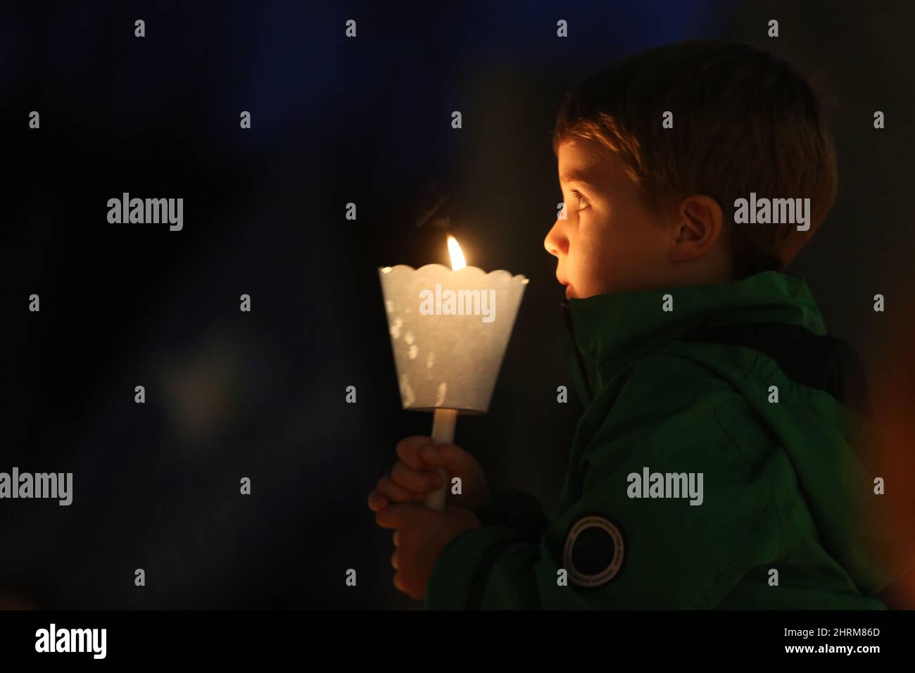 Roma, Italia. 22nd Feb 2022. ROMA, ITALIA, 25.02.2022: Il bambino tiene la torcia durante i manifestanti ucraini e italiani con candele si riuniscono in Piazza del Campidoglio a Roma, contro le operazioni belliche della Russia in territorio ucraino. Credit: Independent Photo Agency/Alamy Live News Foto Stock