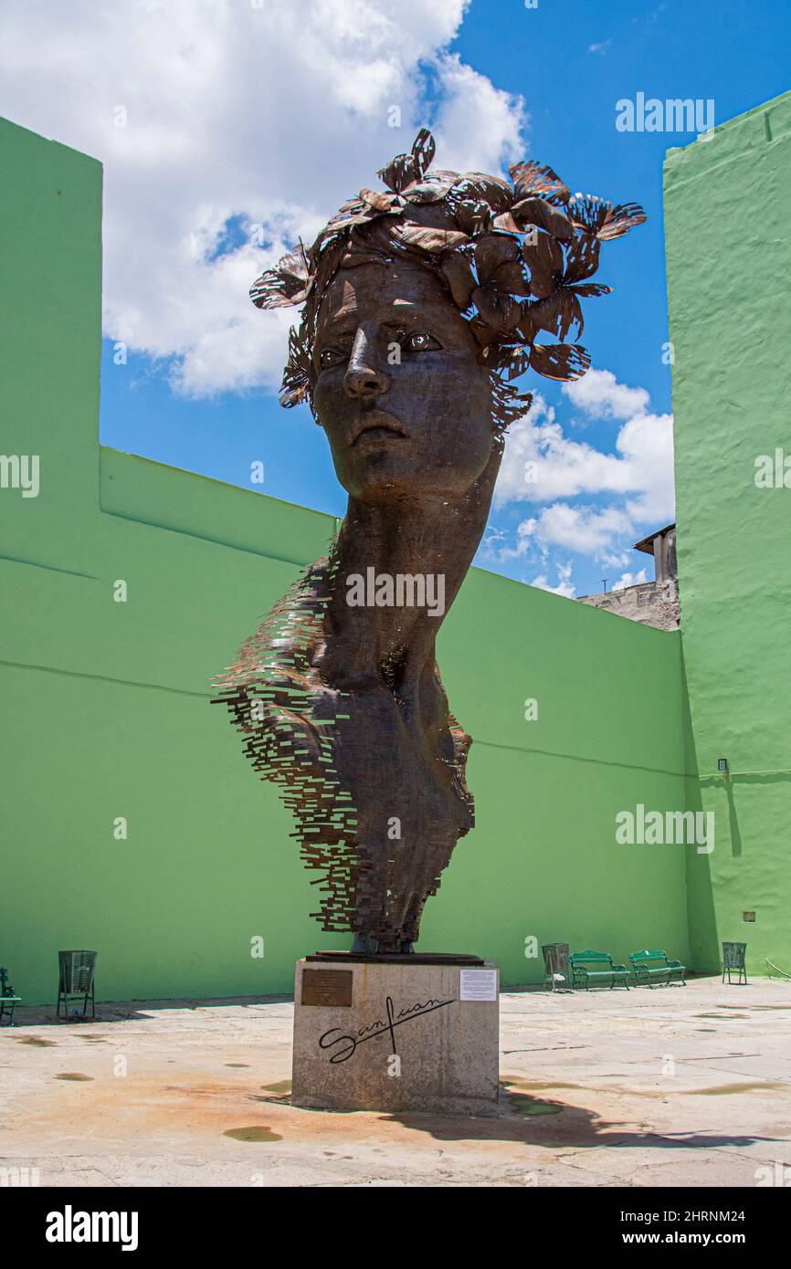 Opera dell'artista cubano Rafael San Juan sul lungomare di Malecon del volto di una grande donna scolpito lungo una strada trafficata. Foto Stock