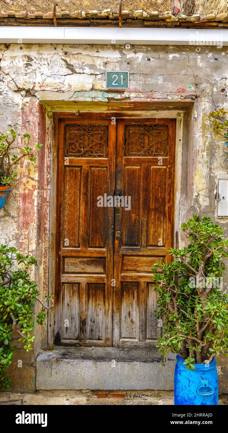 Foto di una vecchia porta di legno di un vecchio edificio con piante sui lati Foto Stock
