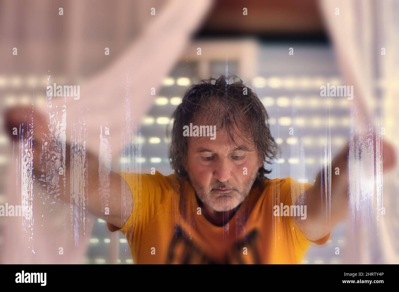 Un maschio adulto caucasico che indossa una camicia arancione che apre la tenda con effetti fantascienza in primo piano Foto Stock