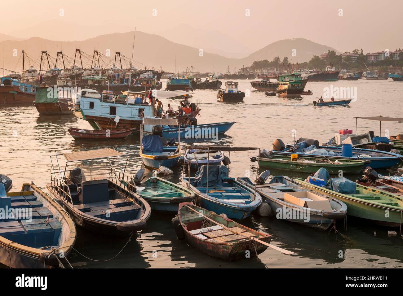 Barche da pesca locali, tra cui tradizionali giunche in legno, sul lungomare di Cheung Chau, un'Isola Outlying dei nuovi territori di Hong Kong Foto Stock