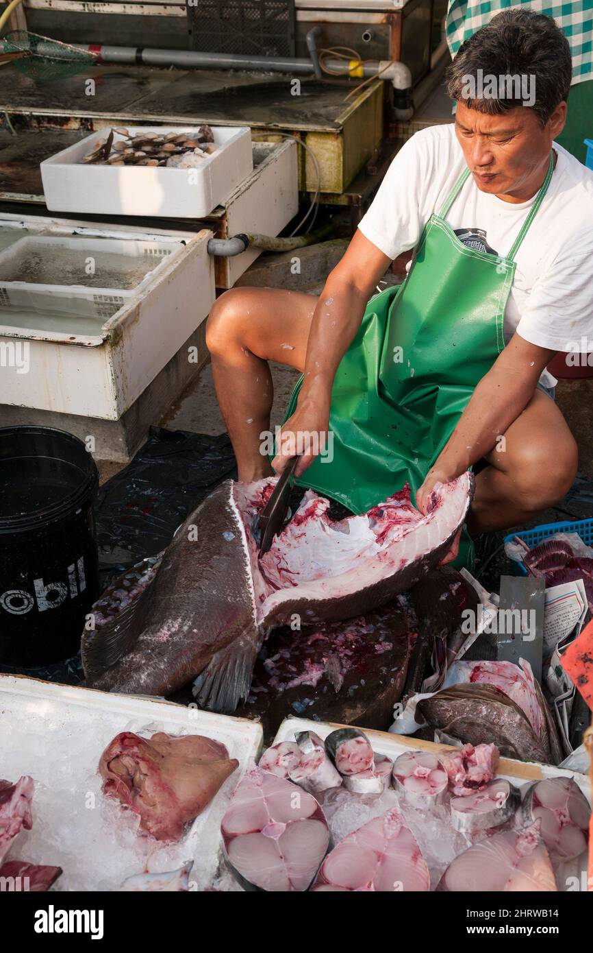 Un pescatore locale pulisce e taglia un grande pesce sul lungomare di Cheung Chau, un'isola Outlying di Hong Kong (sequenza - 7 di 8) Foto Stock