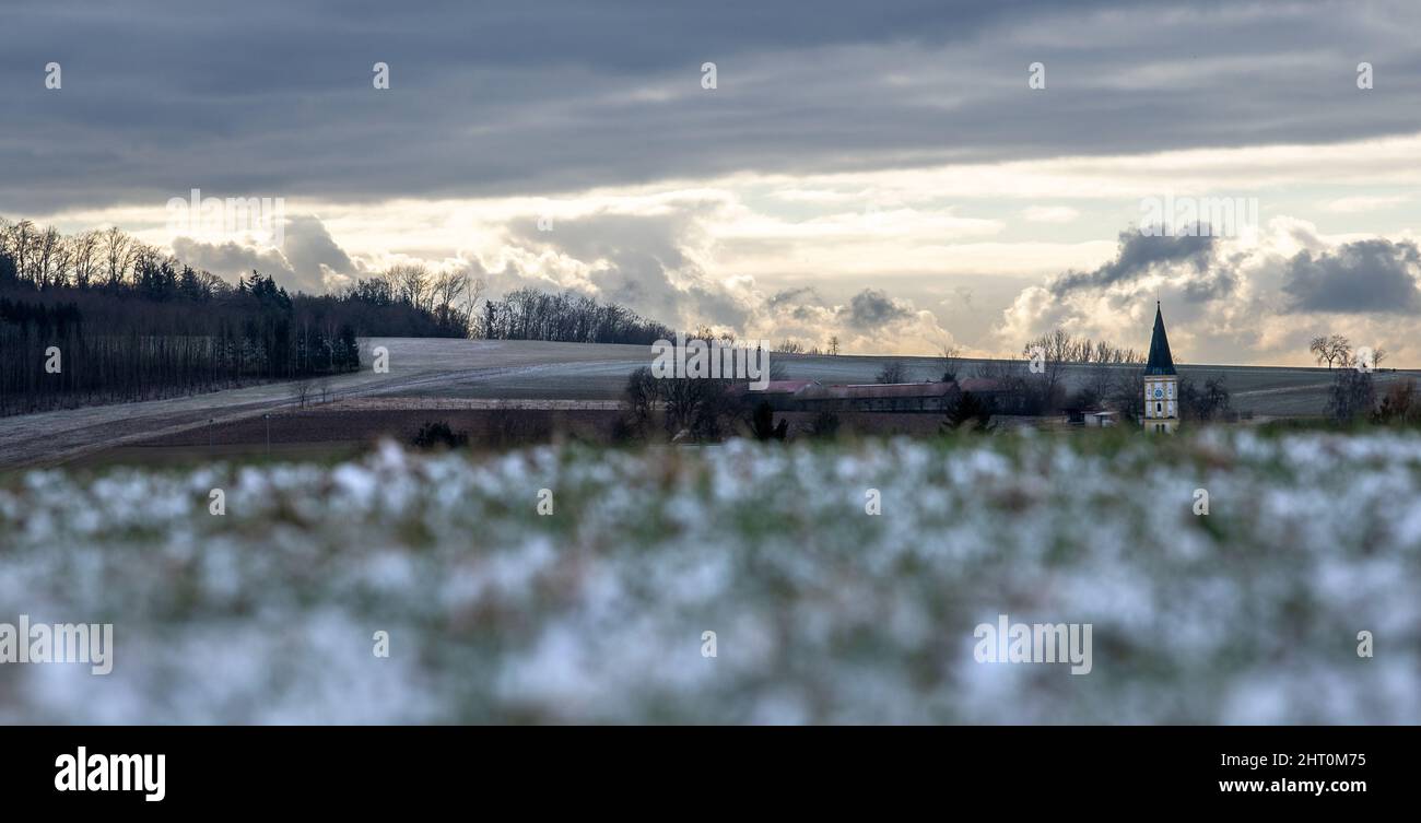 Finningen, Germania. 26th Feb 2022. Il cielo coperto si rompe dietro prati nevosi. Il tempo è instabile, ma dovrebbe diventare più solario nei prossimi giorni. Credit: Stefan Puchner/dpa/Alamy Live News Foto Stock
