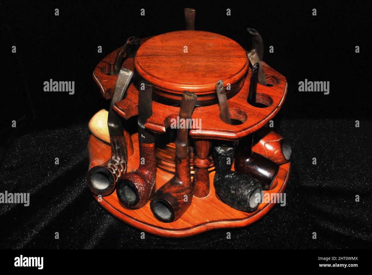 Primo piano di un'annata tubo di tabacco in legno rack marrone con uno sfondo nero Foto Stock