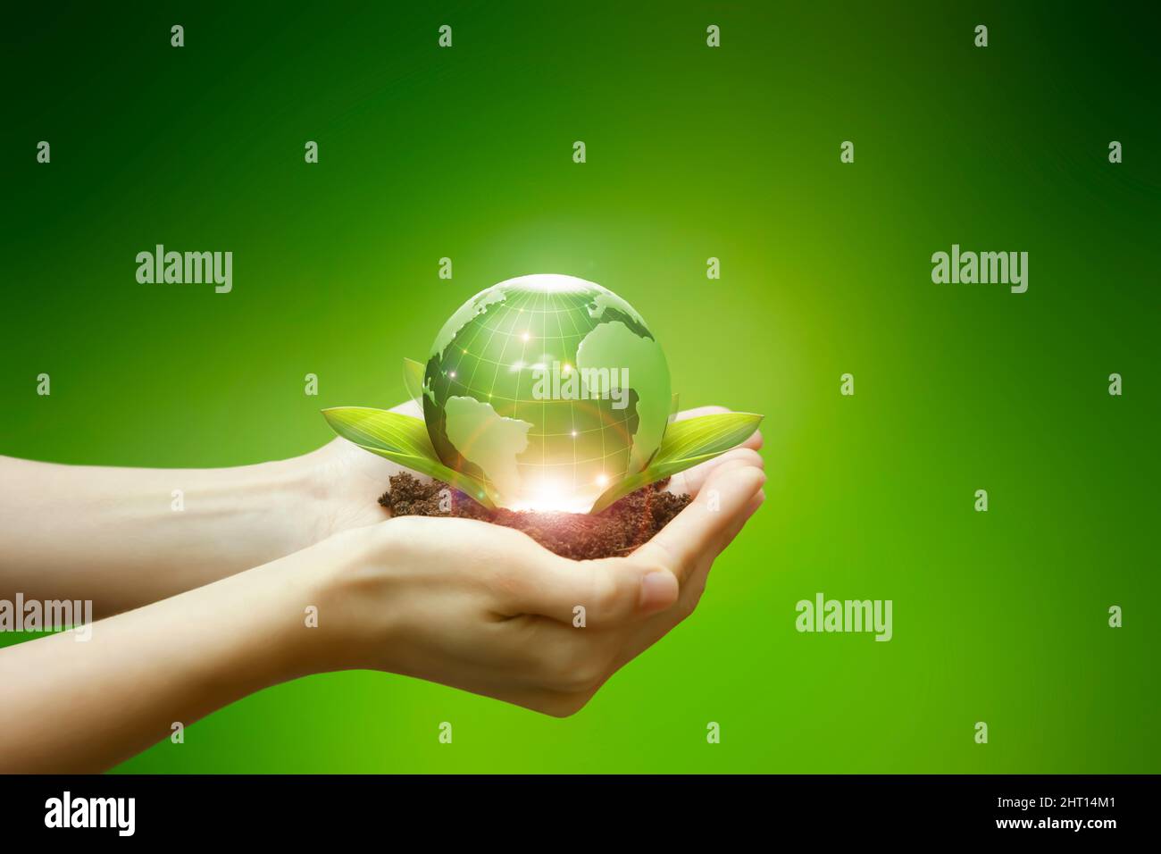Il terreno, le foglie e il globo verde che si trova nel palmo della mano simboleggiano l'industria energetica ecocompatibile. Foto Stock