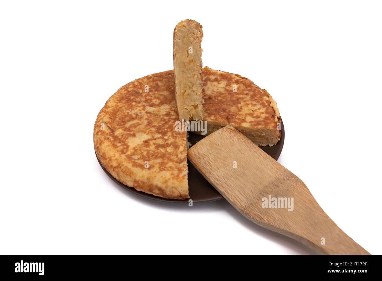 Frittata di patate, conosciuta come 'frittata panish'. Con un cucchiaio di legno. Molto consumato in Spagna. Isolato su sfondo bianco. Cucina spagnola. Foto Stock