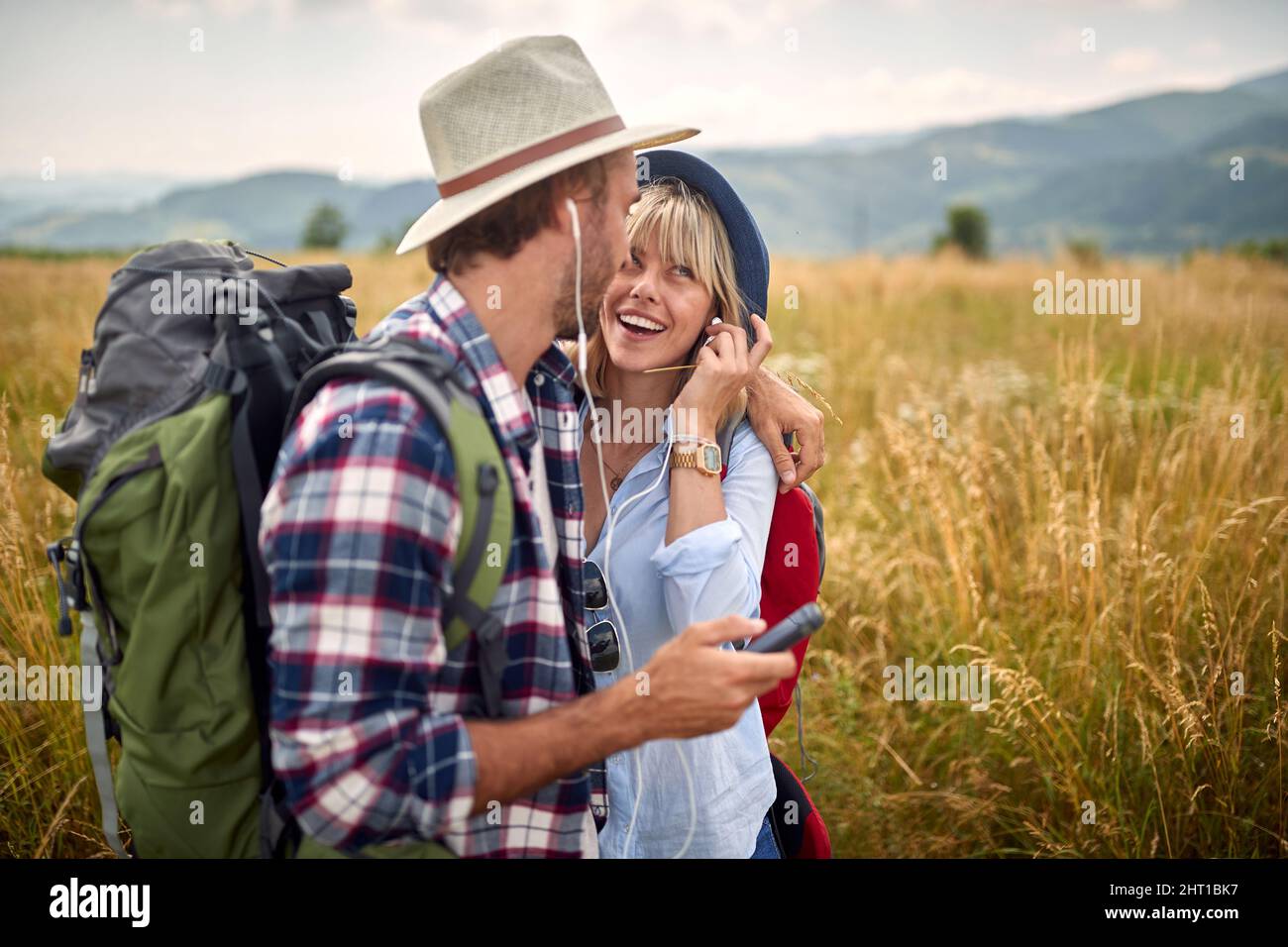 Primo piano di una giovane coppia felice innamorata che è in un abbraccio mentre ama camminare un prato in una bella giornata di sole. Escursioni, natura, rapporto, togethiale Foto Stock