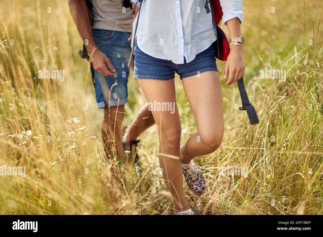 Primo piano di coppia escursioni in campo, tenendo le mani. Natura all'aperto. Coppia caucasica. Sport, libertà, concetto di vacanza. Foto Stock