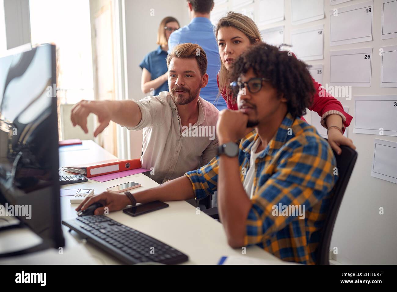 Gruppo di giovani collaboratori diversi che lavorano insieme al progetto Foto Stock