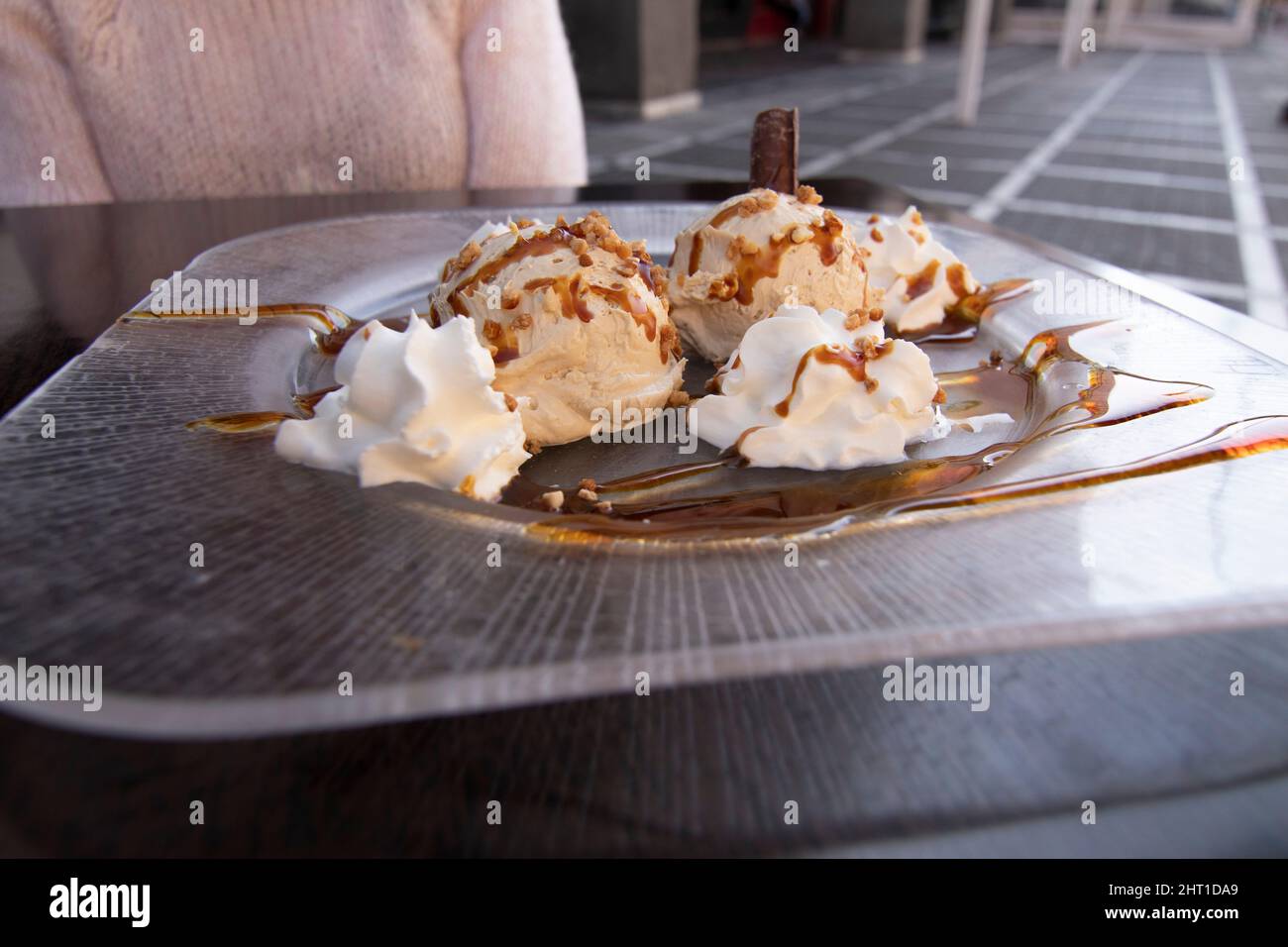 Un dessert molto delizioso. Luis Felipe mousse, cioccolato con crema e caramello. Sullo sfondo una donna non focalizzata. Cucina spagnola. Foto Stock