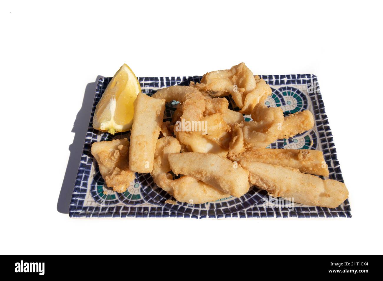 Strisce di seppie fritte, chiamate Chocos Fritos in spagnolo. Servito su un piatto rettangolare decorativo. Cucina spagnola. Foto Stock