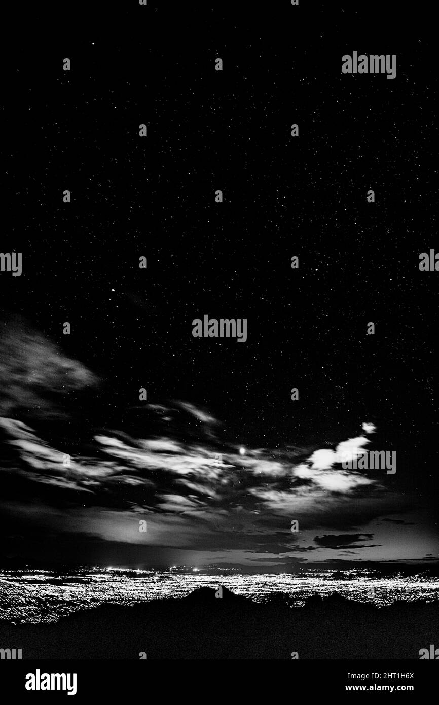 Scala di grigi di un cielo stellato coperto di nuvole sopra Tucson, AZ illuminato dalla luce della città Foto Stock