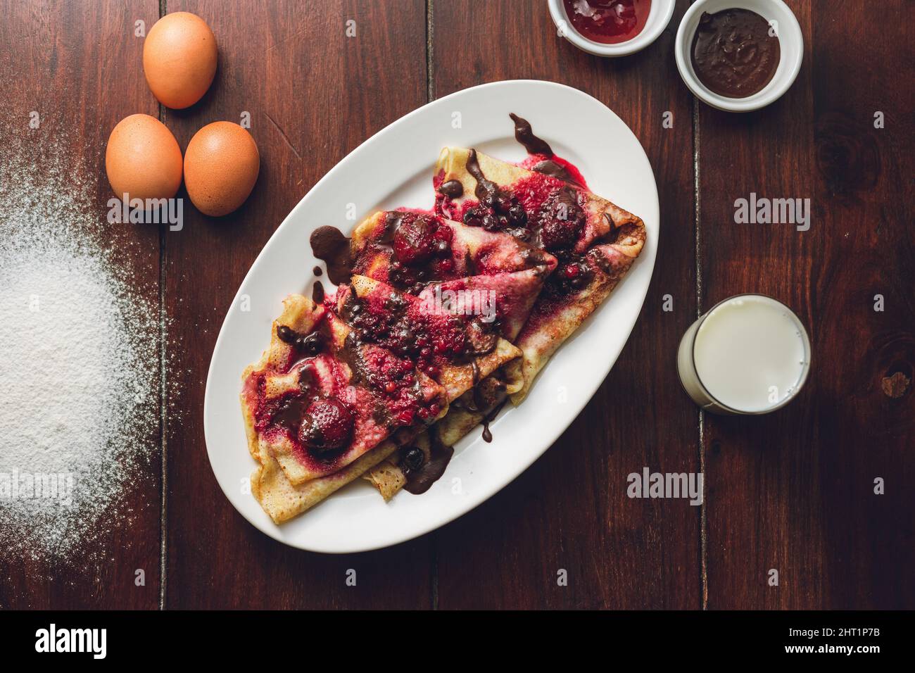 Primo piano delle frittelle con frutta di bosco e cioccolato. Foto Stock
