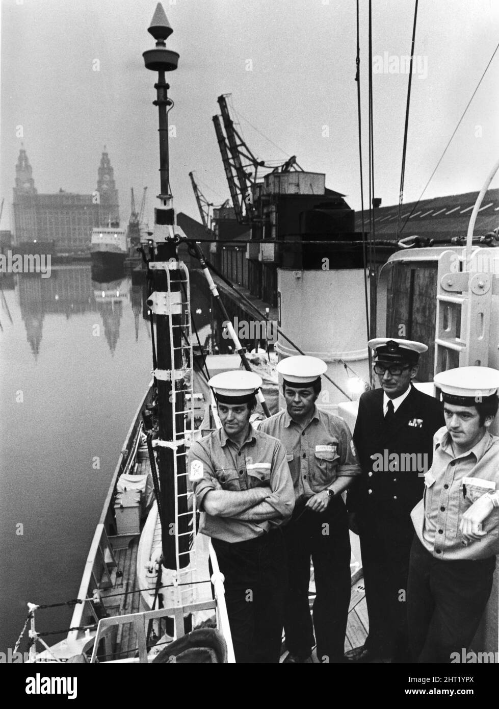 Marinai e ufficiale navale a bordo della minesweeper HMS Mersey, con sede presso il centro di formazione per la Royal Naval Reserve HMS Eaglet. Sullo sfondo si trova il Liver Building sul lungomare di Liverpool. Circa 1966. Foto Stock