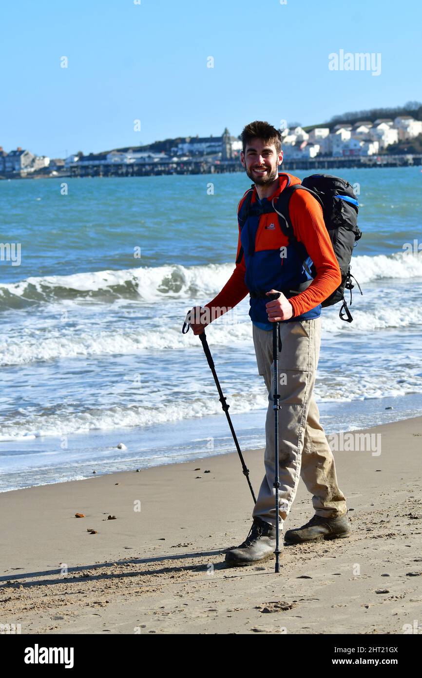 Swanage Dorset, Regno Unito. 26th Feb 2022. Il lungomare britannico di Swanage Rob Stanfield termina l'epica passeggiata Charity di 630 miglia della costa sud-occidentale del Regno Unito da Minehead a Studland in Dorset. Rob Standfield iniziato 2nd febbraio - 26th febbraio. Rob è un paramedico e in suo congedo ha deciso di coprire questo per una carità che ha istituito per raccogliere fondi per l'Air Ambulance per aumentare la consapevolezza circa il suo grande servizio al pubblico generale e salvare vite. Ha alzato oltre £3000. Picture Credit: Robert Timoney/Alamy Live News Foto Stock