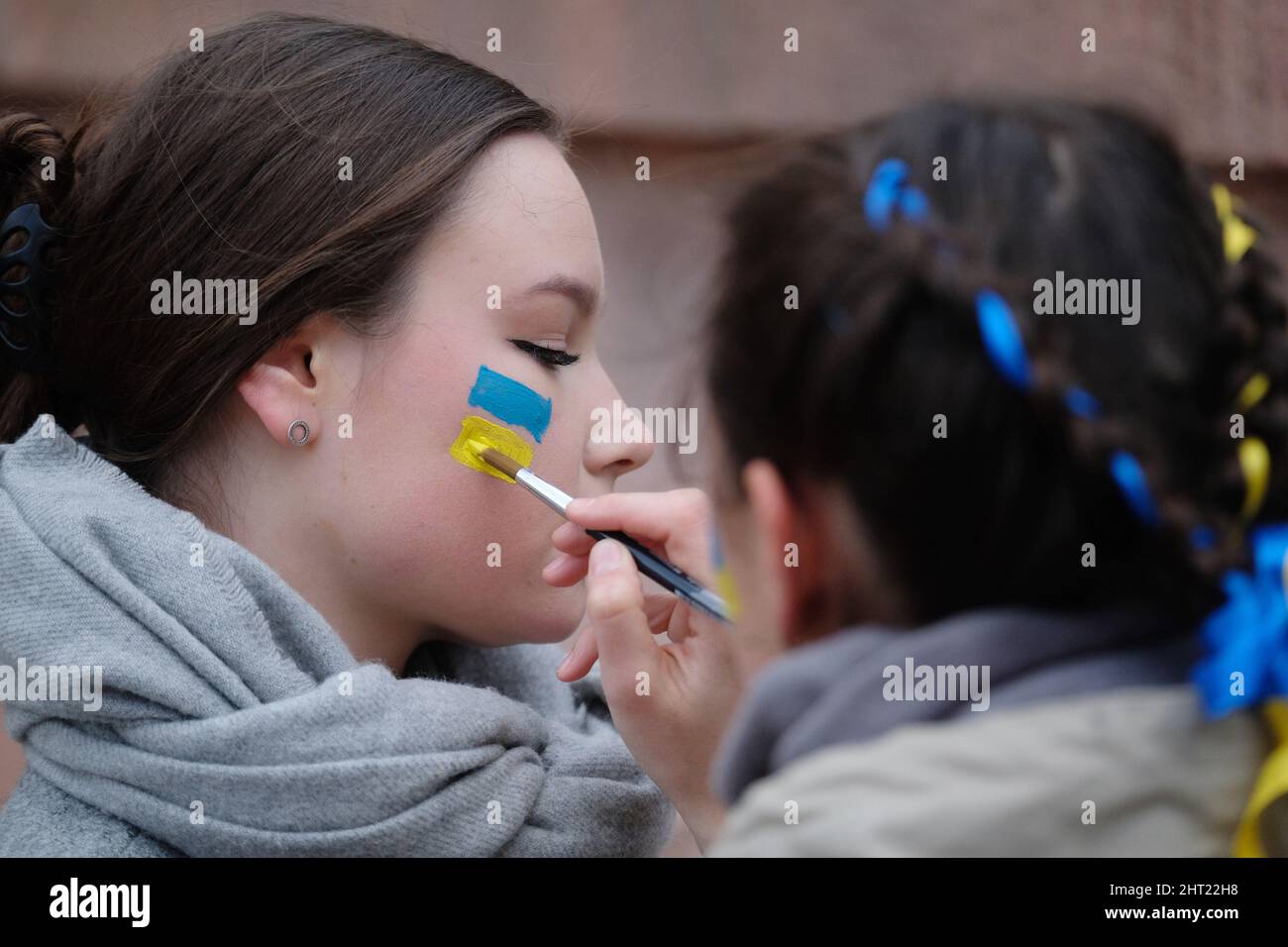 Lipsia, Germania. 26th Feb 2022. Le giovani donne ucraine dipingono i loro colori nazionali sulle guance a margine di un raduno di solidarietà per l’Ucraina. Credit: dpa/dpa-Zentralbild/dpa/Alamy Live News Foto Stock