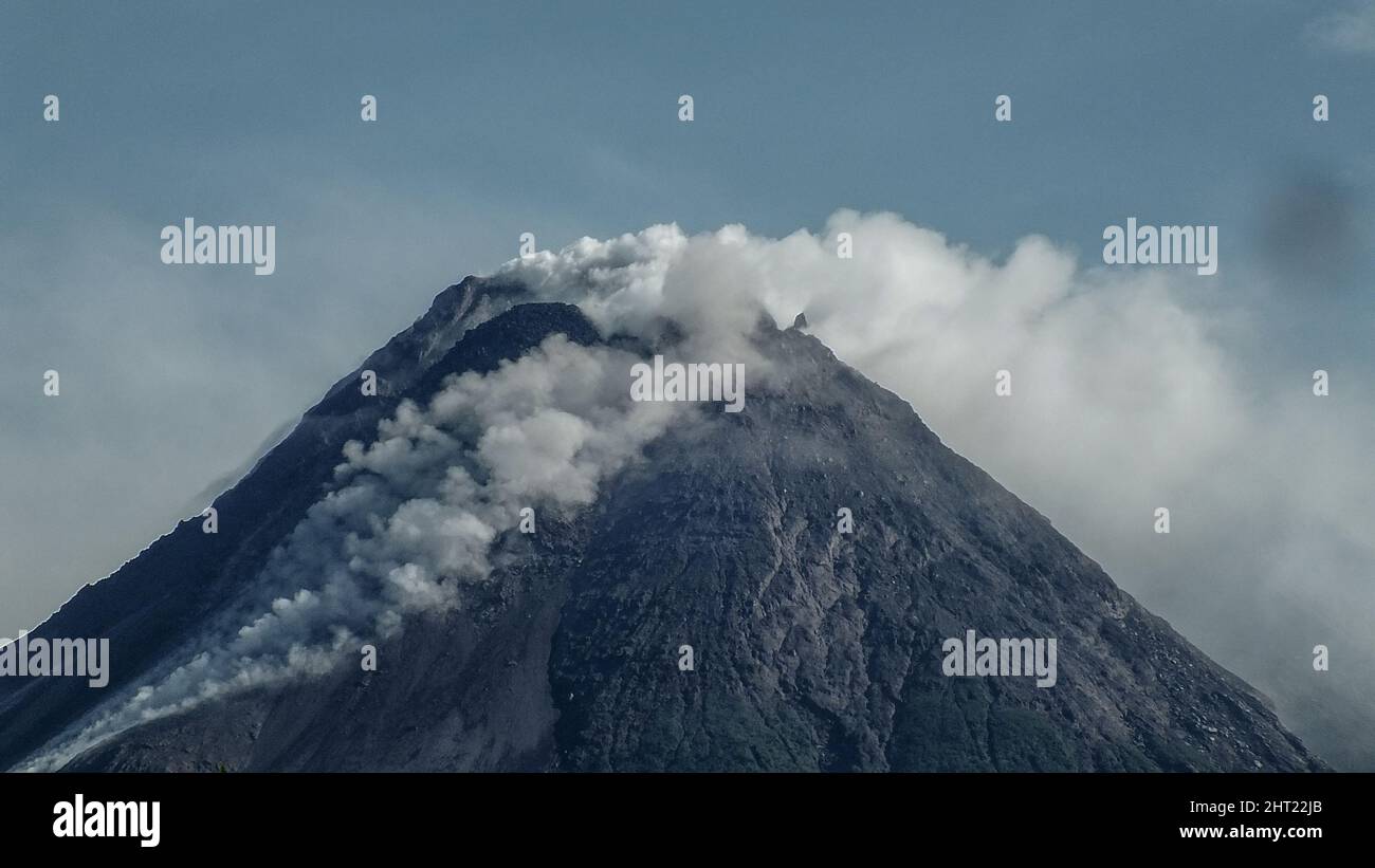 Sleman, Yogyakarta, Indonesia. 26th Feb 2022. Il monte Merapi a Sleman, Yogyakarta, Indonesia, è stato visto rilasciare nuvole calde sulle sue pendici Domenica, 26 febbraio 2022. Secondo i dati dell'Agenzia vulcanica di Yogyakarta, le nuvole calde di valanghe laviche sono state osservate 173 volte a sud-ovest, dominando il fiume Bebeng con una distanza di scorrimento massima di 2.000 metri. Nel frattempo, l'analisi dei dati dei droni ha mostrato che vi erano cambiamenti morfologici nel sud-ovest e nel centro del cratere a causa dell'attività di estrusione sotto forma di valanghe e la crescita della cupola lavica. Il volume del sout Foto Stock