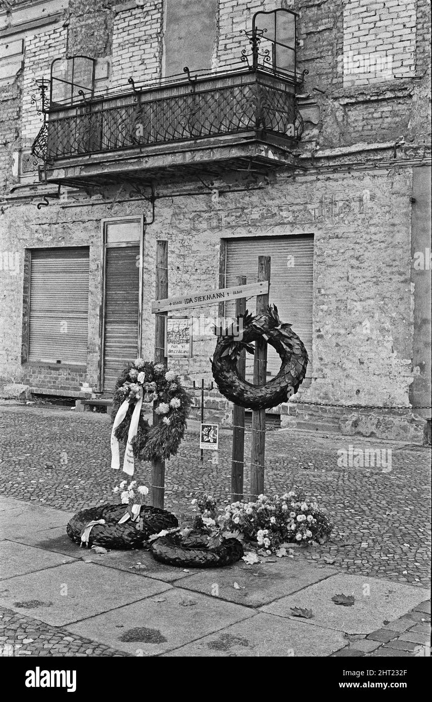 Memoriale di Ida Siekmann, morto dopo aver saltato fuori dalla finestra dell'appartamento a Bernauer Strasse, dopo la chiusura del confine tra Berlino Est e Ovest. Gli edifici sul lato est della strada sono a Berlino Est, e i marciapiedi e la strada a Berlino Ovest. Poiché ciò significava che un residente poteva uscire dalla porta d'ingresso alla libertà, le autorità della Germania orientale ordinarono l'evacuazione forzata di tutte le abitazioni al confine e rimprosero in su tutte le entrate e finestre Ida Siekmann morì cercando di fuggire durante l'evacuazione del suo edificio. Circa 1965 Foto Stock