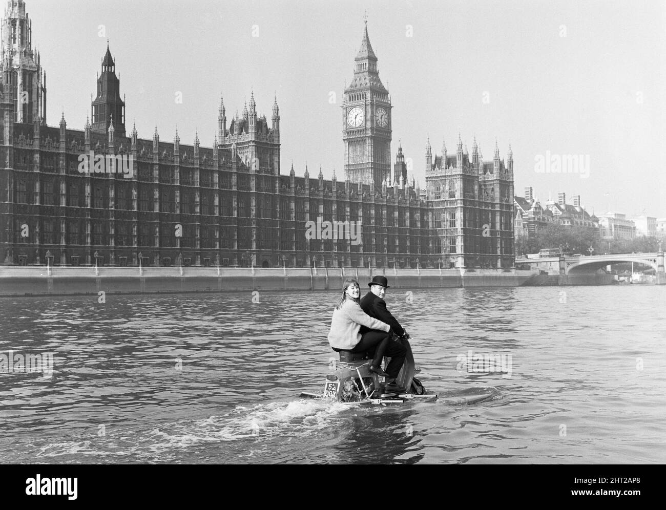 Scootering dell'acqua...di nuovo all'ufficio dopo pranzo?era il uomo d'affari 'dello squartatore Jack Hornsby, con la sua figlia Stella di 17 anni che vela pillion, durante una prova sul Tamigi. Si tratta di uno scooter anfibio dotato di due galleggianti che vengono abbassati prima di entrare in acqua. Una pala fissata alla ruota posteriore, ed è pilotata da un timone comandato dal manubrio 20th ottobre 1965 Foto Stock