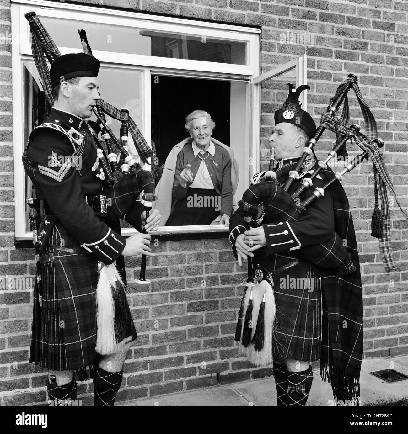 A causa di una richiesta speciale, Sgt. John Gibb (ex Black Watch Guard) e CPL. Glyn Pritchard (ex Queens Own Cammeron Highlanders) gioca cornamuse a Daisy Round (89) alla Old Folks Home di Beacon View, Skelmersdale, Lancashire 6th marzo 1966. *** Local Caption *** Old PeopleSenior Citizens OAP Women Foto Stock