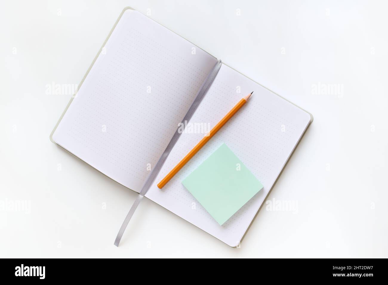 Apri il diario e la matita con vista dall'alto su un tavolo con sfondo chiaro Foto Stock