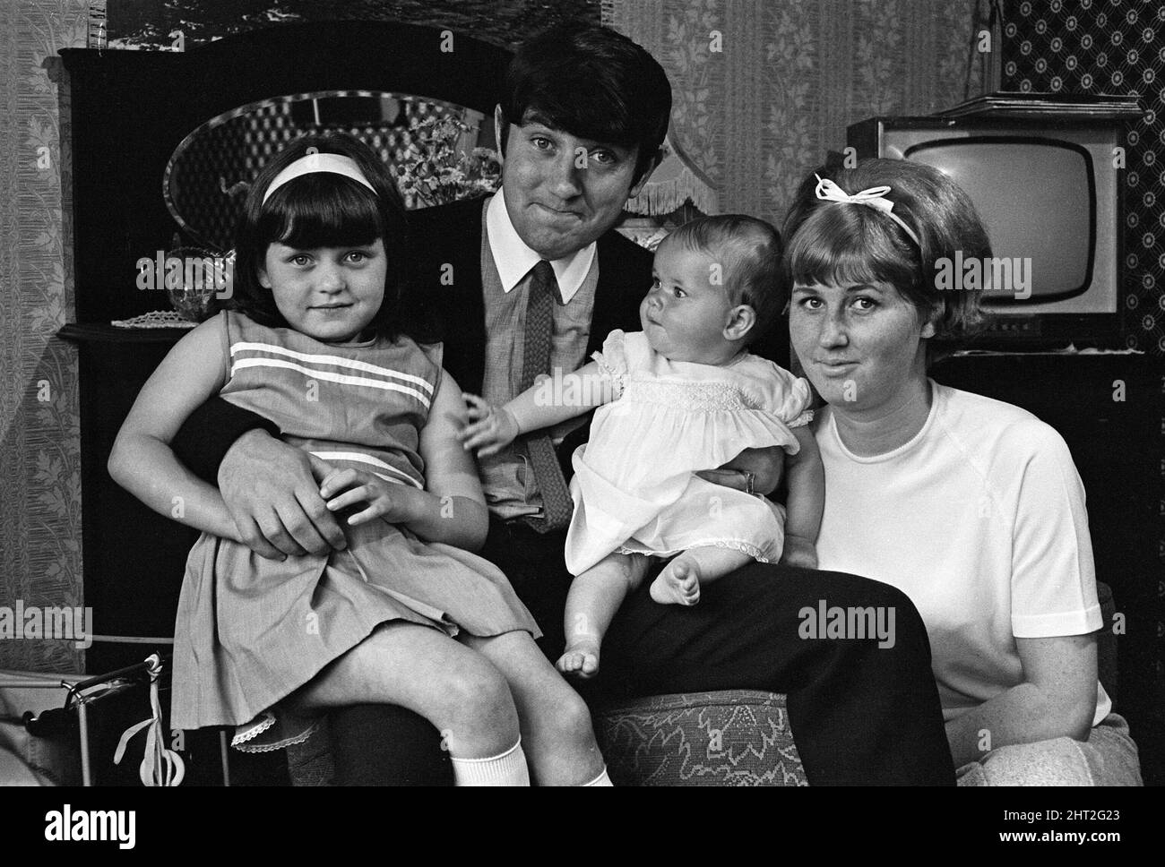 Jimmy Tarbuck a Great Yarmouth con sua moglie Pauline e le loro figlie Cheryl, 5 anni, e Liza, 7 mesi. Jimmy non sapeva per certo a 4pm se stava ottenendo il lavoro Palladium. Ha attraversato la strada dal bungalow dove sta rimanendo per telefonare il suo direttore dal negozio di alimentari del villaggio. 22nd settembre 1965. Foto Stock