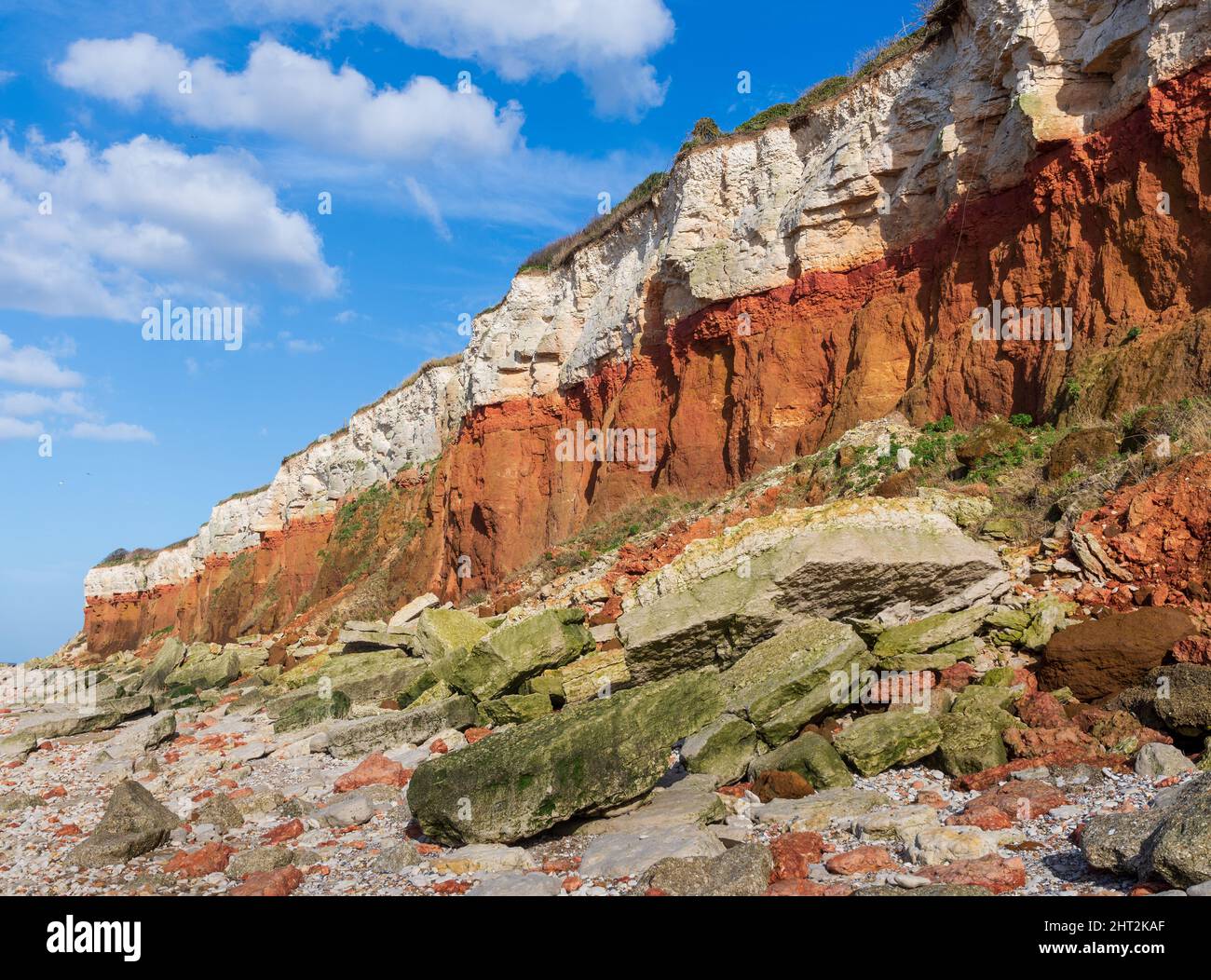 Una pericolosa caduta rocciosa dovuta all'erosione nelle scogliere stratificate rosse e bianche a Old Hunstanton a Norfolk, Regno Unito Foto Stock