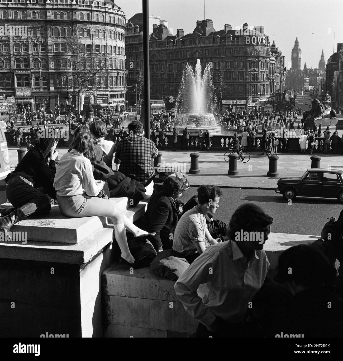 La folla a Trafalgar Square, Londra, godendo di un'ondata di caldo in marzo. 29th marzo 1965. Foto Stock