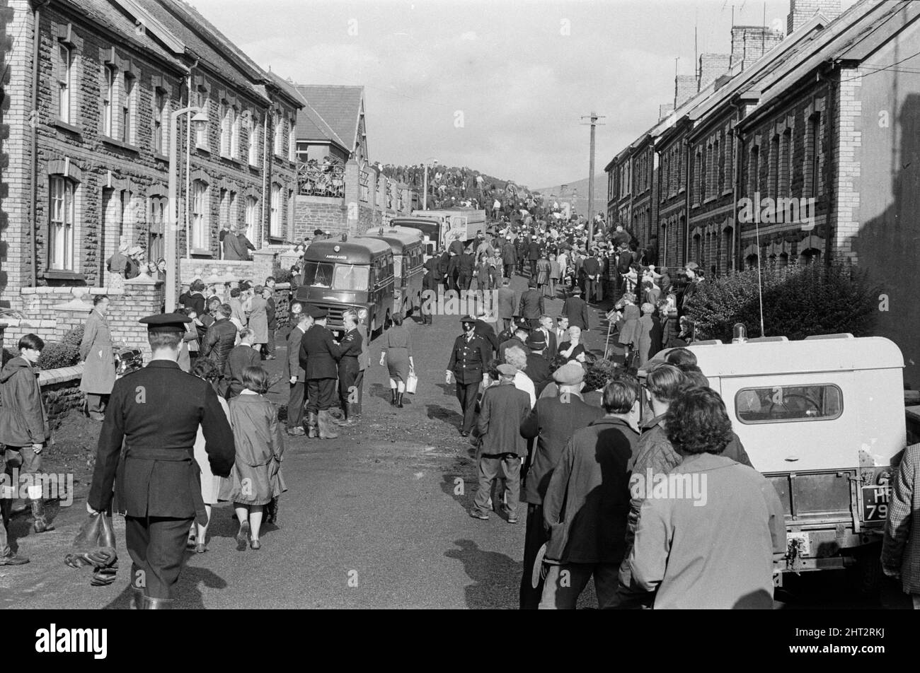 Aberfan, South Wales, circa 21st ottobre 1966 Foto mostra il fango e la devastazione causati quando la miniera di petrolio dalla collina sopra la città dietro è venuto giù e inghiottito la scuola junior Pantglas il 21st ottobre 1966. I soccorritori che cercano di trovare vittime e aiuto, monisti il fango e le macerie intorno al sito della scuola che è alla fine della strada, come si guarda a questa immagine. Il disastro di Aberfan è stato un crollo catastrofico di una punta di petrolio collirica nel villaggio gallese di Aberfan, vicino a Merthyr Tydfil. È stato causato da un accumulo di acqua nella roccia accumulata e scisto, che improvvisamente st Foto Stock