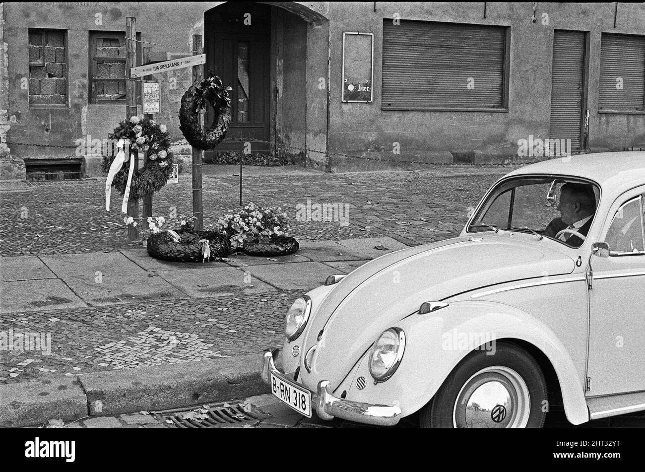 Memoriale di Ida Siekmann, morto dopo aver saltato fuori dalla finestra dell'appartamento a Bernauer Strasse, dopo la chiusura del confine tra Berlino Est e Ovest. Gli edifici sul lato est della strada sono a Berlino Est, e i marciapiedi e la strada a Berlino Ovest. Poiché ciò significava che un residente poteva uscire dalla porta d'ingresso alla libertà, le autorità della Germania orientale ordinarono l'evacuazione forzata di tutte le abitazioni al confine e rimprosero in su tutte le entrate e finestre Ida Siekmann morì cercando di fuggire durante l'evacuazione del suo edificio. Circa 1965 Foto Stock