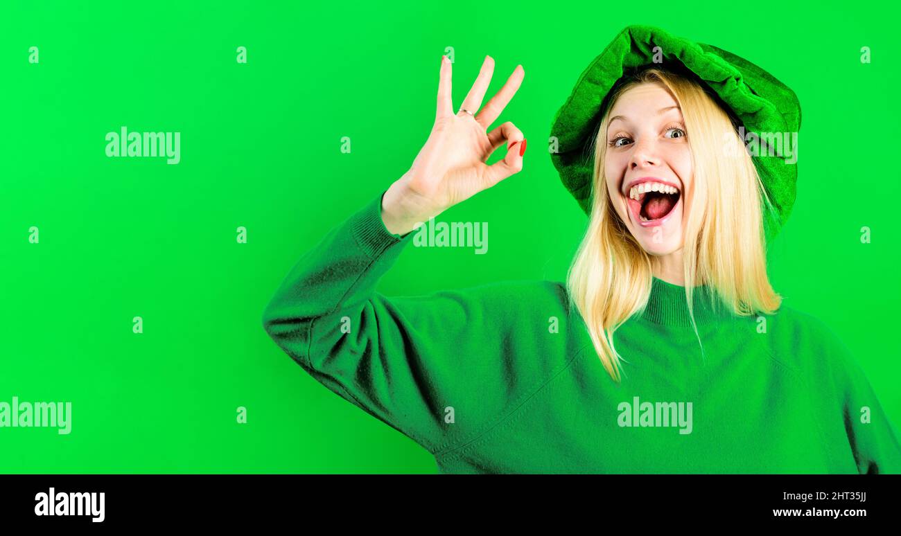 Ragazza felice in cappello verde con segno ok. Festa di Patrick. Vendita. Sconto. Pubblicità. Foto Stock