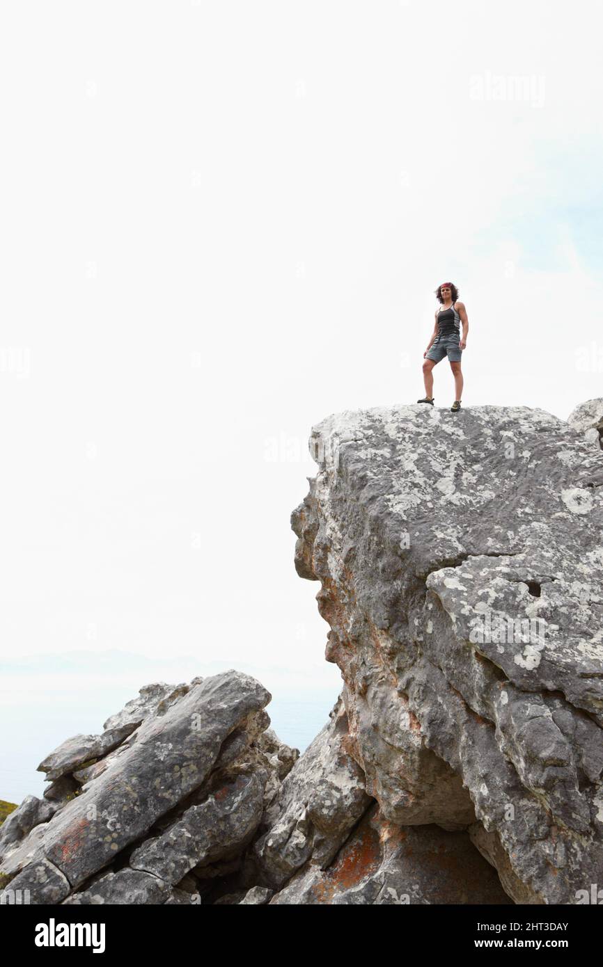 Lasciando il mondo alle spalle. Un arrampicatore di roccia in piedi sulla cima di una scogliera. Foto Stock